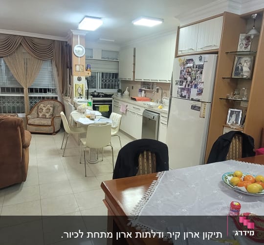 מטבח וסלון ביתי עם שולחן אוכל, כיסאות ומקרר